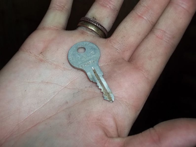 Key Pieces - gray key in person's palm
