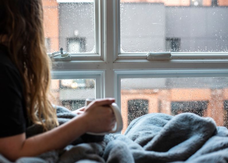 Comfort - woman in gray sweater sitting beside window