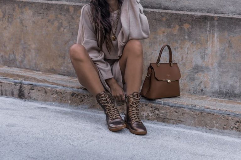 Bag - woman sitting on brown concrete surface wearing brown boots beside brown leather handbag