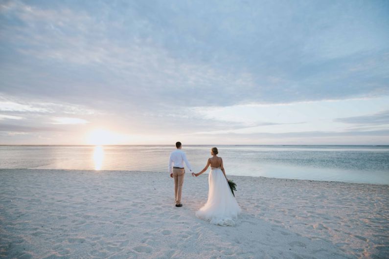 Beach Wedding - man and woman walking on beach during daytime