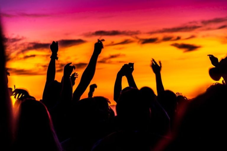 Beach Party - silhouette of people raising their hands during sunset